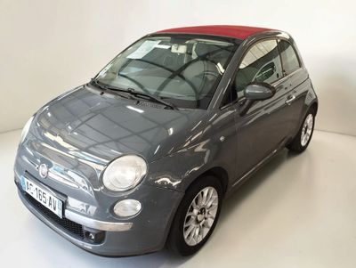 une petite voiture grise au toit rouge garée dans une pièce blanche