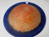 a blue plate with an orange on it sitting on a counter