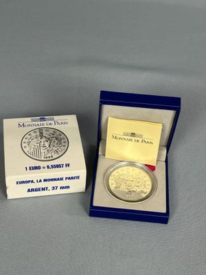 une image représentant une pièce d'argent dans une boîte posée sur une table