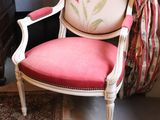 a chair with a pink cushion in front of a fireplace