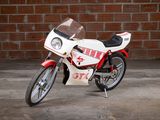 a white and red motorcycle parked in front of a brick wall
