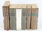 plusieurs livres sont alignés sur une surface blanche