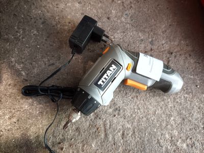 an image of a corded electric drill on the ground