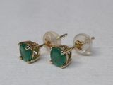 paire de boucles d'oreilles à clous ornées de pierres vertes sur fond blanc
