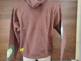 a brown hoodie on a mannequin display in a room