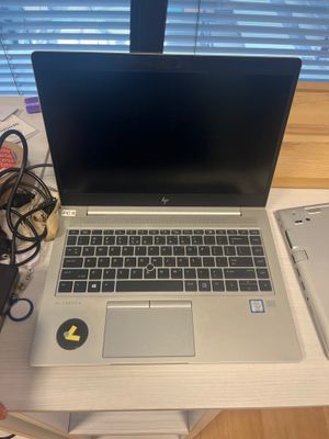 a laptop computer sitting on top of a desk next to a cell phone