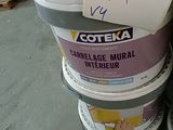 several buckets of paint are stacked on top of each other in a warehouse
