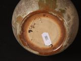 a brown vase with a tag on it sitting on a table