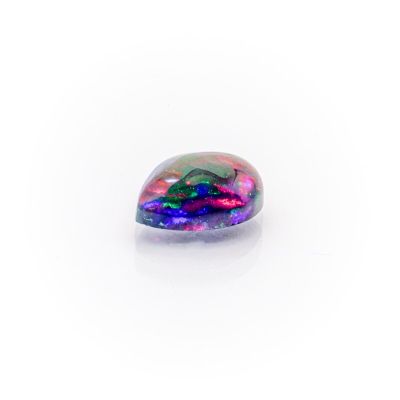 a rainbow colored stone sitting on top of a white surface