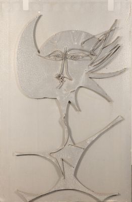 une sculpture en verre représentant le visage d'une femme, accrochée au mur