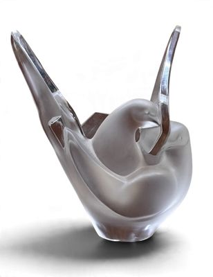 une sculpture en verre représentant un oiseau perché dans un bol