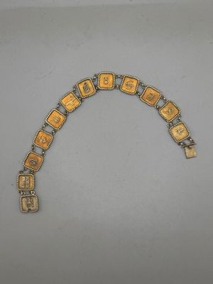 a close up of a gold bracelet with squares on it