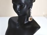 black bust of a woman with earrings and a necklace on a white surface