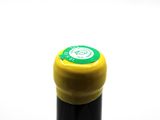 a close up of a bottle of wine with a yellow cap