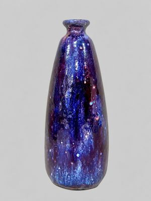 a purple and blue vase sitting on top of a table