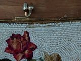 a close up of a beaded purse with a rose on it