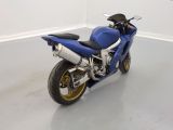 a blue motorcycle that is parked in a white room