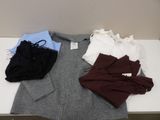 un tas de vêtements posés sur une table, avec une étiquette dessus