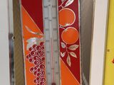 a picture of a thermometer sitting on a shelf next to a picture