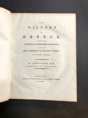 un livre ouvert posé sur une table, sur fond noir