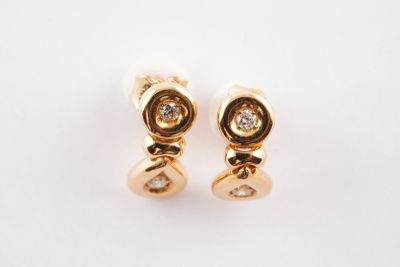 une paire de boucles d'oreilles en or et diamants sur fond blanc