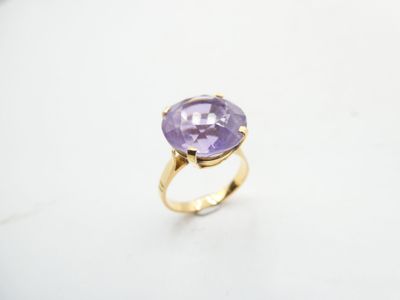 a close up of a ring with a purple stone on it