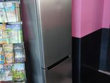 a silver refrigerator in a pink room with a checkered floor
