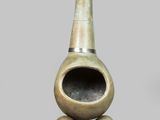 un petit vase en bronze à long col, posé sur un socle