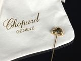 un petit sac blanc orné d'une broche dorée