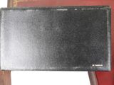 black leather wallet sitting on top of a red chair next to a book