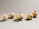 four wooden vases are lined up in a row on a gray surface