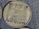 four different types of silver coins on a blue cloth