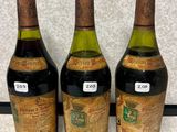 trois bouteilles de vin posées les unes à côté des autres sur un plan de travail
