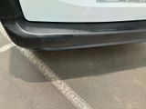 a close up of a white car parked in a parking lot