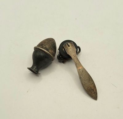 deux petits objets métalliques posés sur une surface blanche