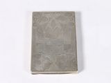 a silver book with a picture on it on a white surface