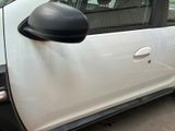 a white car with a black side mirror on the side of the road