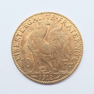 gros plan d'une pièce d'or sur une surface blanche