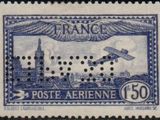 a close up of a stamp with an airplane flying over a city
