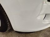 a close up of a white car ' s front bumper