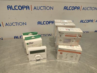 three boxes of electronic devices are sitting on a table in front of an alcopa auction sign