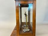a small wooden clock with a glass case on top of it
