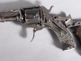 un vieux pistolet avec une poignée en bois sur une surface blanche