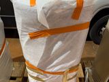 un grand sac de provisions posé sur une palette à côté d'une camionnette