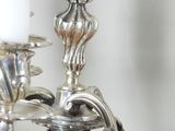 a silver candle holder with a white candle on it