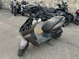 a scooter that is parked in front of a stone wall