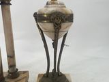 two antique bronze and marble vases on stands with a bird on top