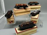 quatre types différents de trains miniatures exposés dans une vitrine