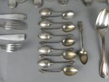 many spoons and forks laid out on a table