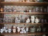 un meuble en bois contenant beaucoup de vaisselle et de tasses